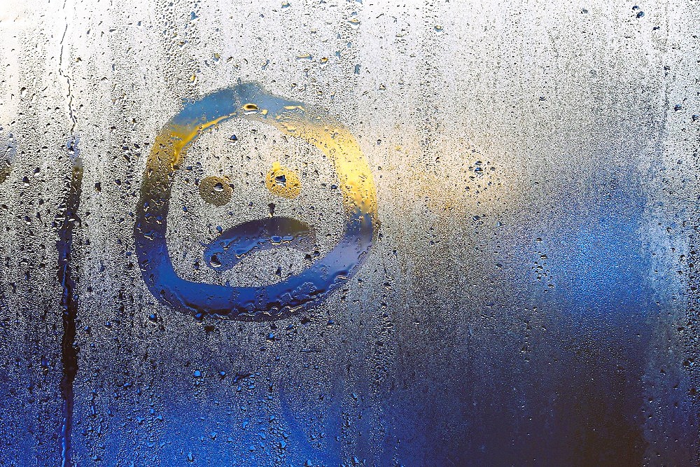 sad emoticon on a misted window